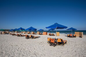 Ligstoelen aan het strand, parasols