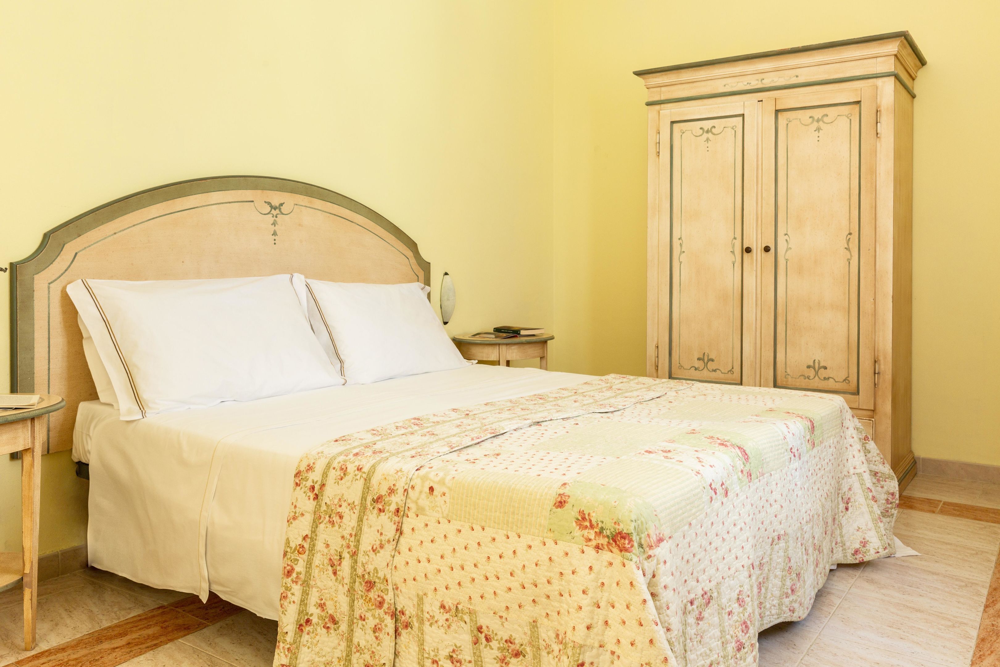 Une chambre à coucher avec un lit, une table de chevet et une armoire en bois.