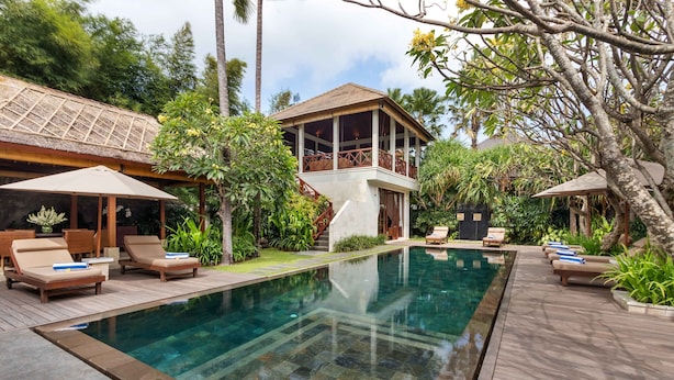 A pool area with lounge chairs and a covered seating area. - Villa Rubina (Seminyak)
