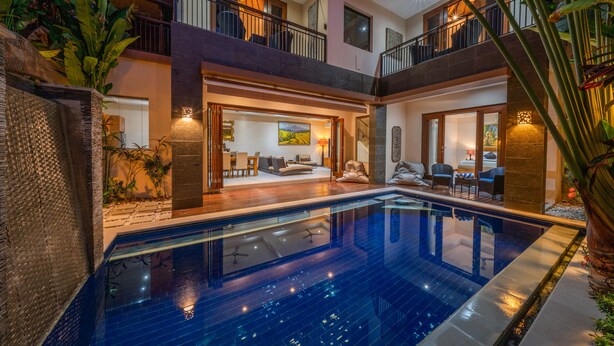 A two-story house with a swimming pool, outdoor seating, and a balcony. - Villa Seacluded 1 (Seminyak)