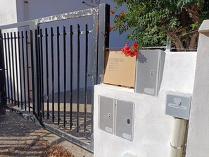 A gated entrance with a mailbox and a utility box.