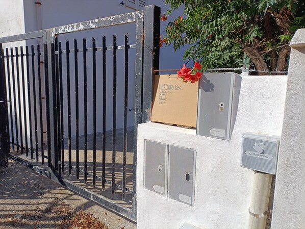 A gated entrance with a mailbox and a utility box.