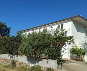 Un bâtiment blanc avec un toit plat et un petit porche.
