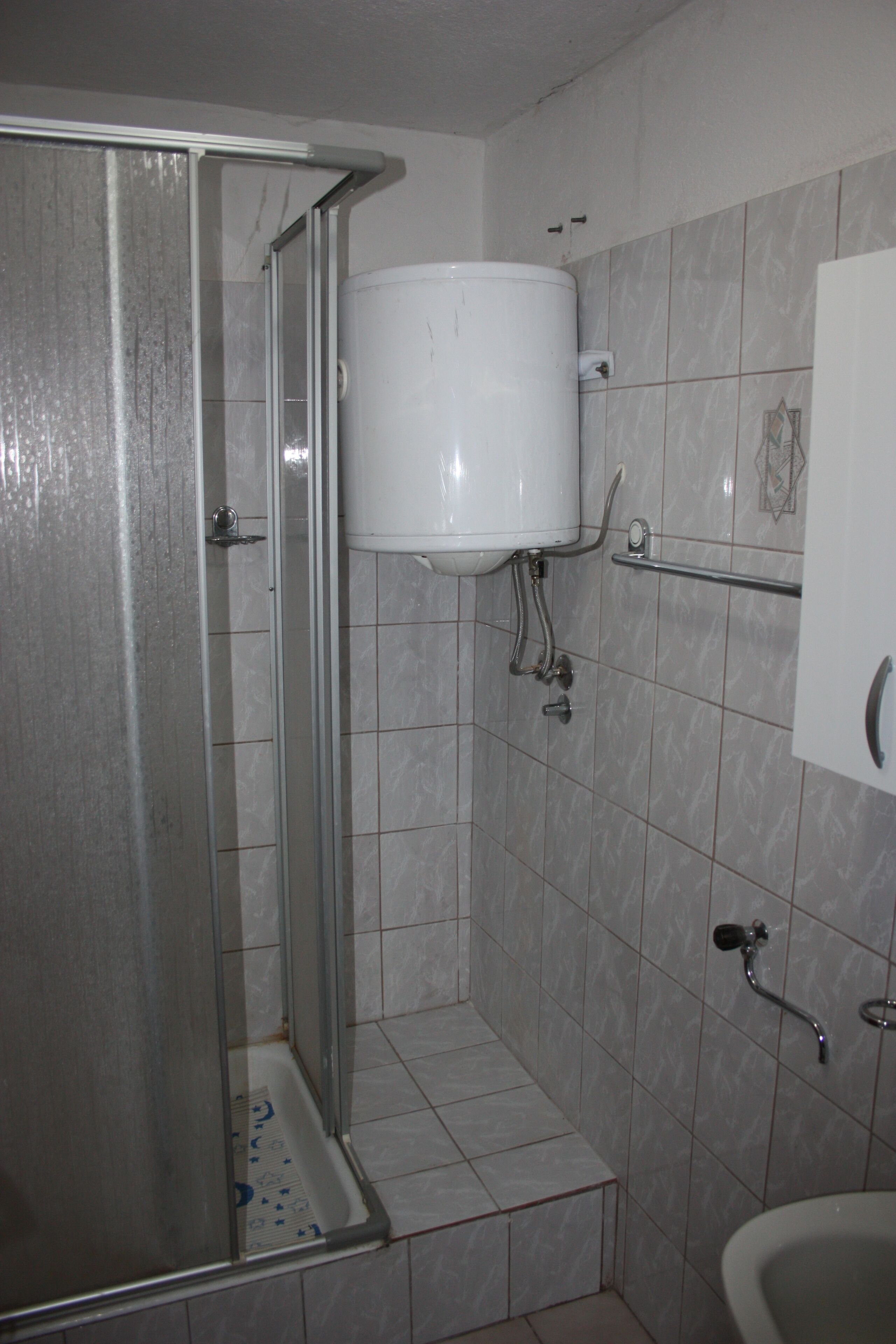 Ein Badezimmer mit Dusche, Toilette und Waschbecken.