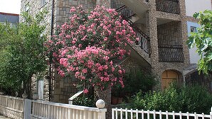 A multi-story building with stone facade, balconies, and a white fence. - Relax Adriatic House (Omis)