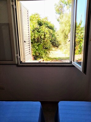 A room with a window overlooking a garden. - Tertenia Ground Floor South 3 min Walk From the sea (Tertenia)