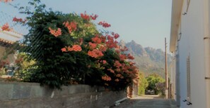 A narrow street with a building on the right and mountains in the background. - Tertenia Ground Floor South 3 min Walk From the sea (Tertenia)