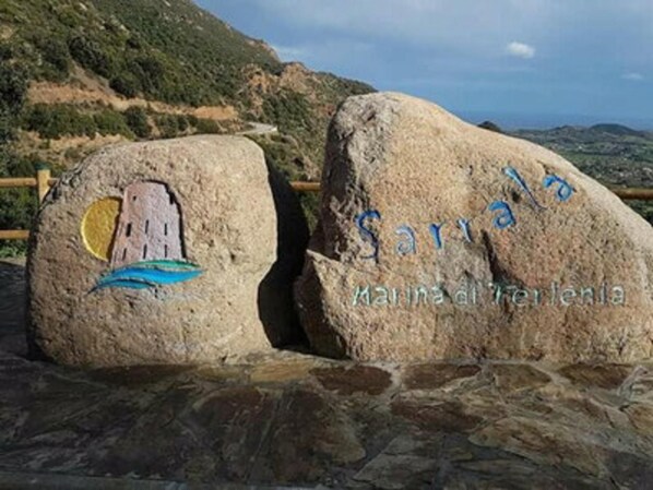 Two large rocks with the text 'Sarrala' and 'Manna del Terlenia' engraved on them.