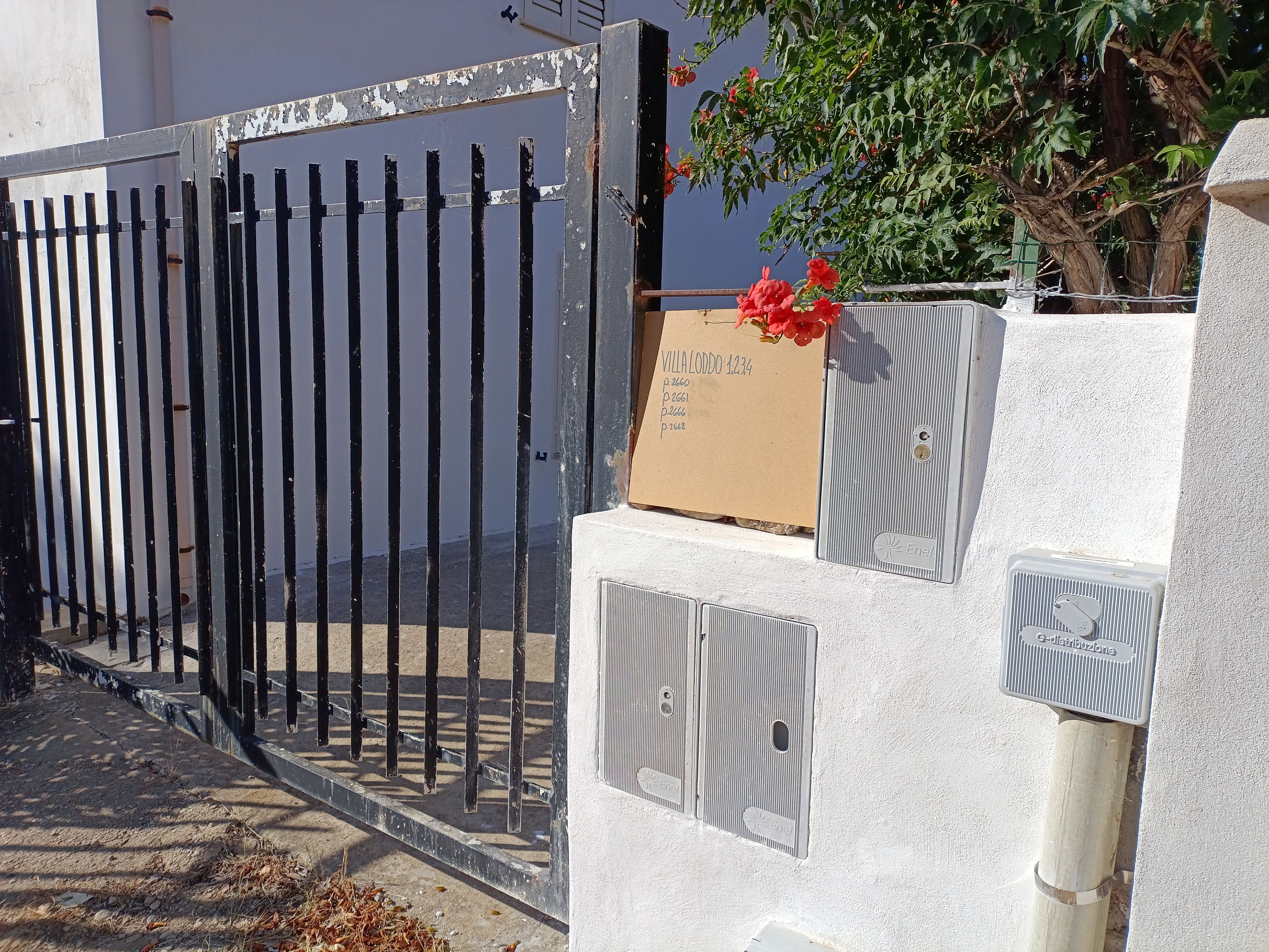 A gated entrance with a mailbox and a utility box.