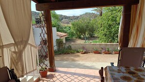 A patio with a view of a garden and hills. - Tertenia Ground Floor South 3 min Walk From the sea (Tertenia)