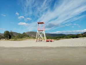 A lifeguard tower on a beach with a clear sky and mountains in the background. - Tertenia Ground Floor South 3 min Walk From the sea (Tertenia)