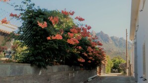 A narrow street with a building on the right and mountains in the background. - Tertenia Ground Floor South 3 min Walk From the sea (Tertenia)