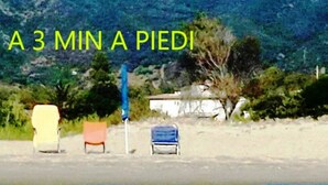 A beach scene with three chairs and a blue umbrella. - Tertenia Ground Floor South 3 min Walk From the sea (Tertenia)