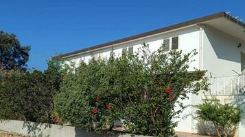 A white building with a flat roof and a small porch.