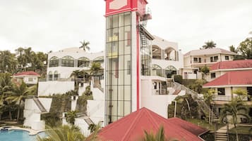Ein Resort mit einem zentralen Turm, mehreren Balkonen und einem Swimmingpool.