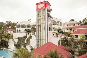 A resort with a central tower, multiple balconies, and a swimming pool.