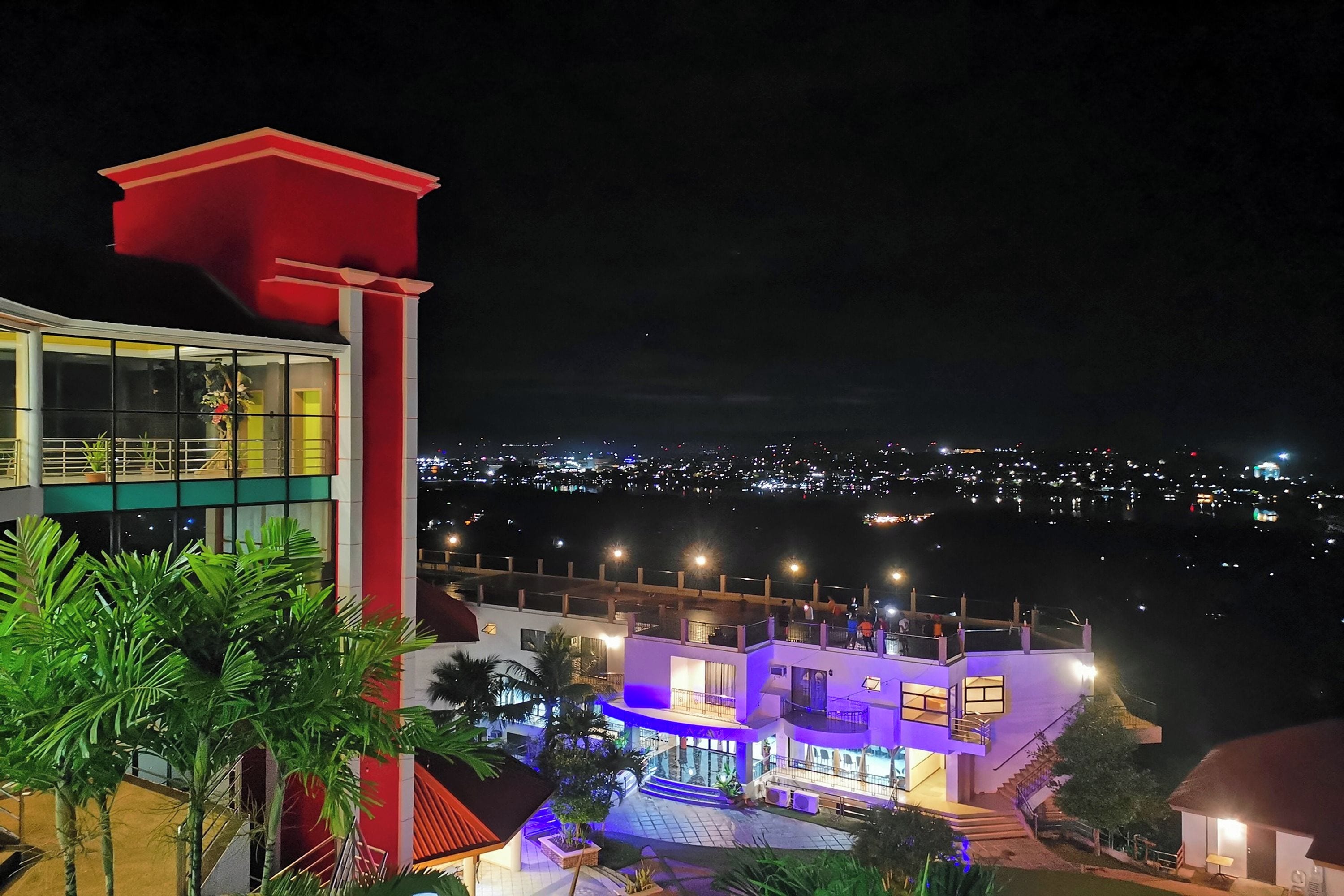 Un edificio de varios pisos con un balcón, una escalera y una zona de piscina.