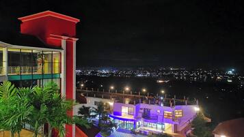 Un edificio de varios pisos con un balcón, una escalera y una zona de piscina.