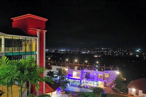 Un edificio de varios pisos con un balcón, una escalera y una zona de piscina.