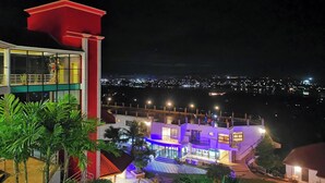 Un edificio de varios pisos con un balcón, una escalera y una zona de piscina.