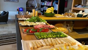 Buffet amb diferents plats, com pa de motlle, verdures i patates fregides.