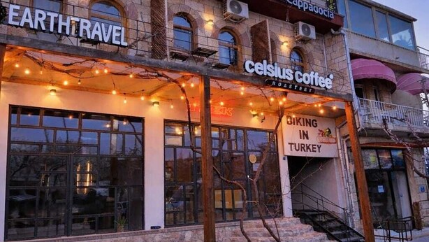 Un edifici amb un gran globus aerostàtic, una cafeteria anomenada Celsius Coffee, i un cartell de Earth Travel.