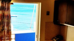 A room with a view of the sea through a window, a door, and a tiled wall. - Homy Lovely House Near the Sea (Archanes-Asterousia)