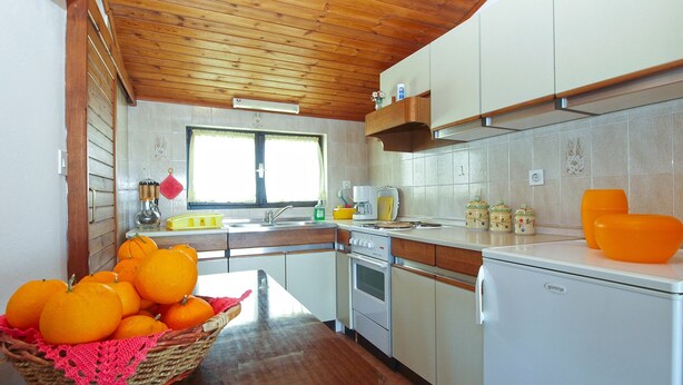 A kitchen with wooden ceiling, white cabinets, a sink, and a refrigerator. - Apartment 2003/28453 (Istria - Premantura), 500m from the beach (Premantura)