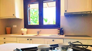 A kitchen with a window, a sink, and a tray with two cups.
