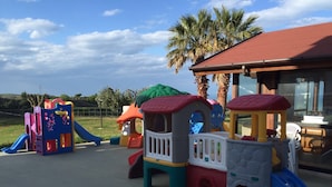 A playground with various play structures including slides and climbing areas.