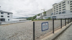 A gravel parking area with a sign for Hotel Urbanisland. - Hotel Urban Island (Namhae)