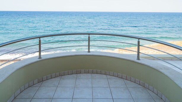 Uma varanda com vista para o mar e a praia.
