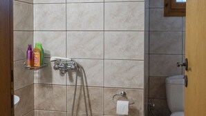 Ein Badezimmer mit Dusche, Toilette und Waschbecken.