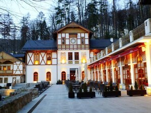 Ein traditionelles Chalet mit einer symmetrischen Fassade, großen Fenstern und einem zentralen Eingang.