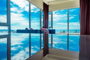 A room with a large window offering a view of the ocean and city skyline. - Panorama Baku - 22 Floor (Baku)