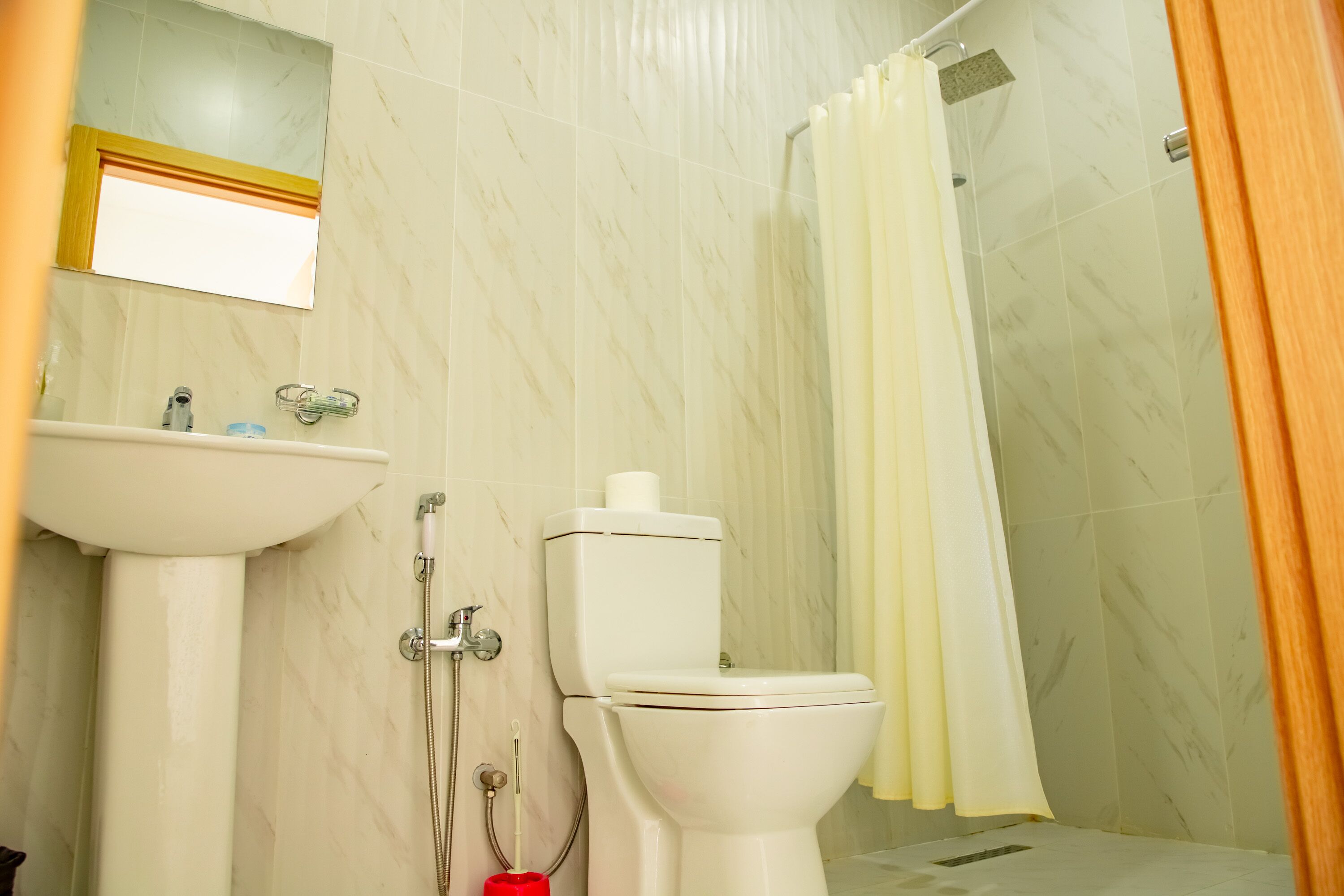 A bathroom with a sink, toilet, and shower.