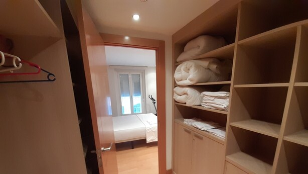 Um quarto com uma cama, um guarda-roupa e um armário.
