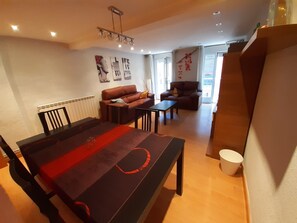 Un espace repas comprenant une longue table, deux canapés et une petite table basse.