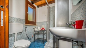 A bathroom with a toilet, a sink, a shower, and a tiled floor. - Villa Elena 2 Km From the Natural Reserve of Zingaro (Castellammare del Golfo)