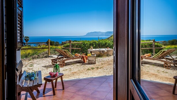 A patio with a view of the sea, wooden furniture, and a barbecue grill. - Villa Elena 2 Km From the Natural Reserve of Zingaro (Castellammare del Golfo)