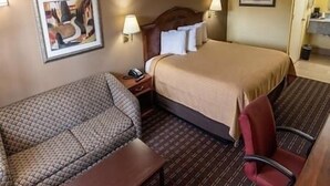 A hotel room with a bed, a chair, a desk, and a lamp. - King Room Non-Smoking (Hawkinsville)