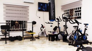 Ett gym med olika typer av träningsutrustning, inklusive löpband, motionscyklar och styrketräningsmaskiner.