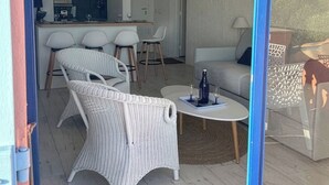 Zona d'estar moderna i diàfana, amb cuina, menjador i espai per seure.