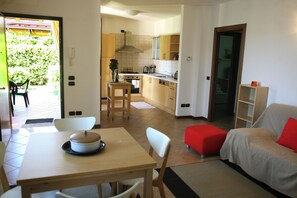 A compact living space with a dining area, kitchen, and a sofa. - Apartments "i Ciclamini" a Moniga del Garda (Moniga del Garda)