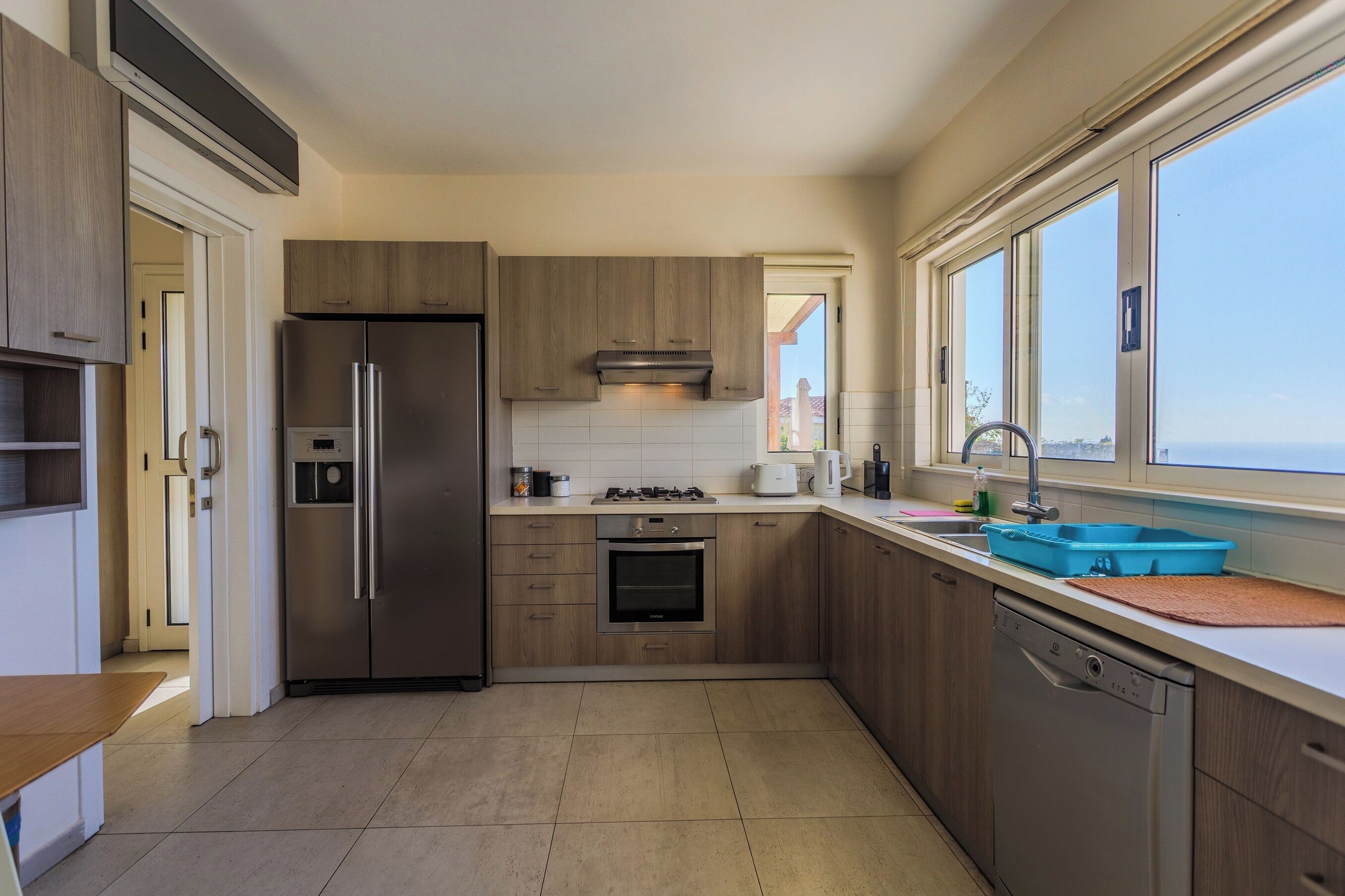 Una cocina moderna con refrigerador, horno y lavavajillas de acero inoxidable.