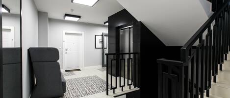 Ein modernes Interieur mit Treppe, Tür und gemustertem Boden.