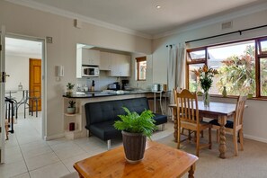 Relax in this cozy living space with a central seating area, dining table, and kitchenette.