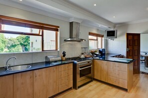 Enjoy cooking in this well-equipped kitchen with a central island, stove, and flat-screen TV.