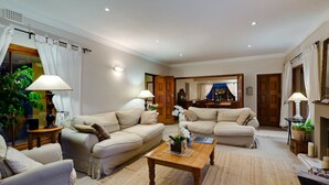 A spacious living room with two sofas, a coffee table, and a fireplace. - Lavender Cottage 2 Double Bedrooms 2 Bathrooms both on suite Beautiful Views (Cape Town)