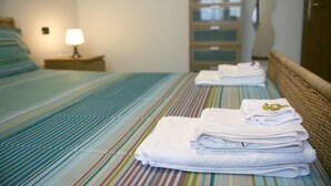 Une chambre d’hôtel avec un lit, une table de chevet avec une lampe et une armoire vitrée.